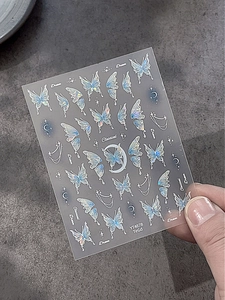 Holographic butterfly nail art stickers with dream word motifs on stone background