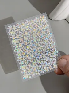Detailed macro view of laser holographic floral nail art stickers with rainbow glitter