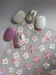 Close-up of pearlescent shell flower nail stickers with 3D floral art on lilac nails
