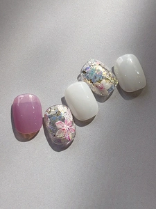 Detailed macro view of purple and white press-on nails with cherry blossom floral patterns