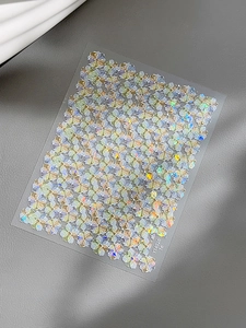 Macro detail of 3D iridescent shell flower nail stickers with sparkling holographic finish