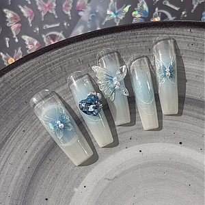 Dreamy blue gradient press-on nails with 3D butterfly, crystal heart, and pearl accents