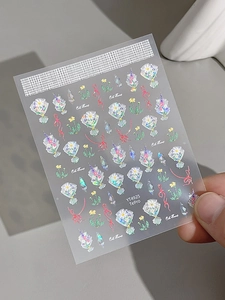 Close-up of cute floral nail stickers with glitter bows and colorful ribbons