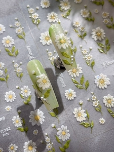Detailed close-up of 5D white daisy nail art stickers with 3D pearl embellishments
