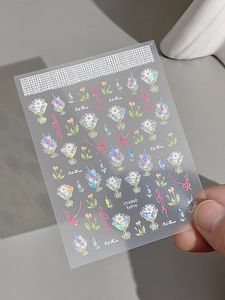 Macro view of holographic nail art stickers featuring cute flowers and pink bows