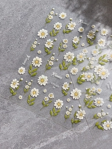 Close-up of 5D embossed daisy nail art stickers showing detailed floral relief textures