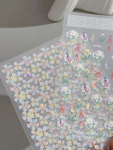 Detailed close-up of holographic shell flower and bow nail art stickers with laser finish