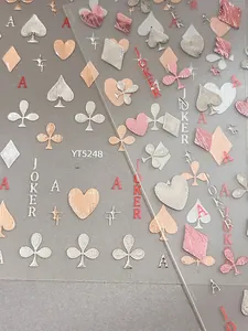 Macro detail of rose gold and silver poker nail stickers with embossed hearts and spade icons
