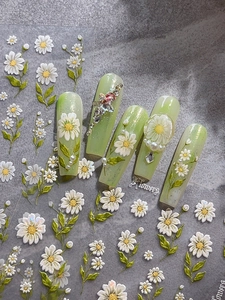 Detail of 3D embossed daisy nail stickers applied on gradient green long false nails