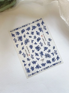 Detail of blue and white porcelain nail decals with peony, butterfly and Chinese calligraphy