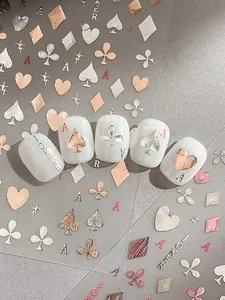 Detailed macro view of 3D metallic rose gold poker nail art stickers with heart motifs