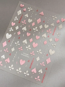 Detail of rose gold poker nail stickers with hearts, clubs and joker motifs on transparent backing