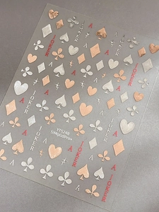 Macro detail of rose gold and silver poker embossed nail stickers with heart patterns