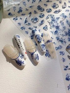 Detail of blue and white porcelain nail stickers with Chinese calligraphy and pearl accents