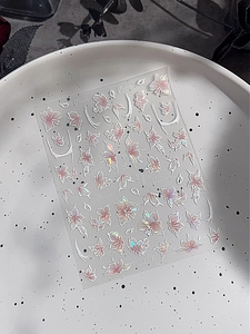 Dettaglio macro di adesivi per unghie laser olografici a fiori su un piatto in ceramica