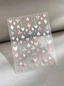Detailed close-up of poker-themed nail art stickers with pink hearts and silver stars