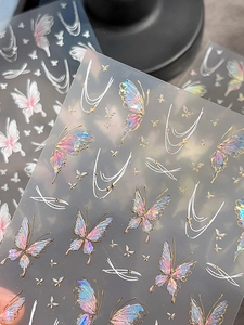 Close-up of laser iridescent butterfly nail stickers with gold foil and white line details