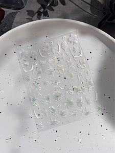 Vista macro di adesivi olografici per unghie con disegni floreali iridescenti