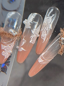 Dettaglio di adesivi per unghie 3D con fiori, farfalle e decorazioni di perle