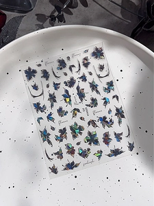 Dettaglio di adesivi per unghie con fiori laser colorati e rose metalliche su ceramica