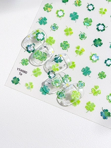 Détail d'autocollants trèfle vert et marguerite sur faux ongles transparents YT4980