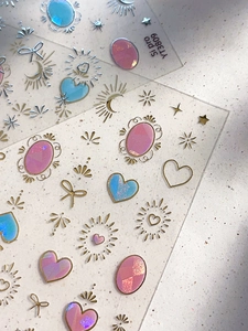 Dettaglio degli adesivi olografici per nail art con cuori e stelle in lamina d'oro