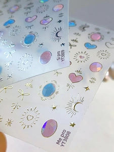 Dettaglio macro di adesivi 3D olografici per unghie con cuori e riflessi iridescenti