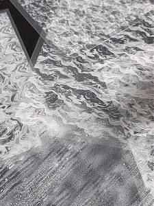Détail macro de l'autocollant nail art motif vagues abstraites et texture fluide grise