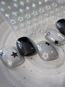 Vue macro d'autocollants pour ongles étoilés noirs et gris translucides brillants