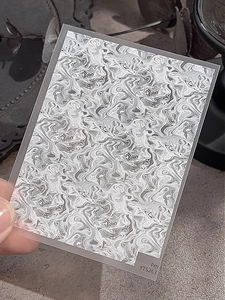 Vue macro de stickers d'ongles ultra-fins avec motifs marbrés fluides gris et blancs