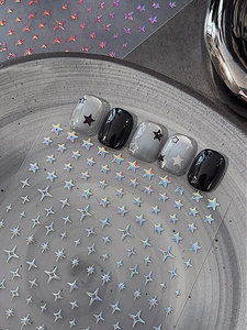 Vue détaillée de stickers pour ongles étoiles argentées laser sur faux ongles foncés