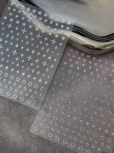 Autocollants holographiques dorés pour ongles en forme d'étoiles sur fond de pierre sombre