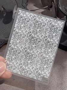 Détail d'autocollant nail art ultra-fin montrant une texture de vague blanche sur base grise