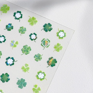 Autocollants à ongles trèfle à quatre feuilles en vert et blanc avec des reflets dorés