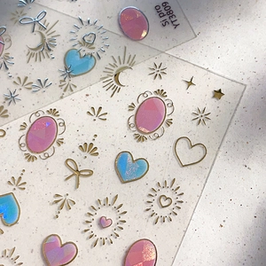 Adesivi per unghie dorati con cuori e fiocchi in tonalità rosa e blu sfumate