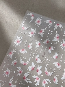 Détail d'autocollants gaufrés pour ongles avec fleurs blanches et dégradé rose de jardin
