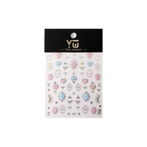 Adesivi per nail art con cuori dorati, fiocchi pastello e stelle su scheda di supporto