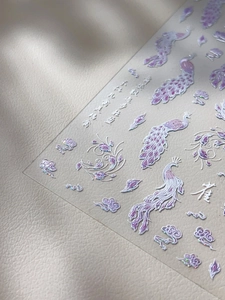 Detail of laser holographic nail stickers with peacock and Chinese calligraphy motifs