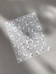 Détail macro de stickers pour ongles marguerites blanches avec motifs floraux sur cuir gris