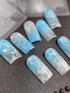 Vue macro de stickers ongles vagues bleues avec texture gouttes d'eau 3D sur ongles carrés