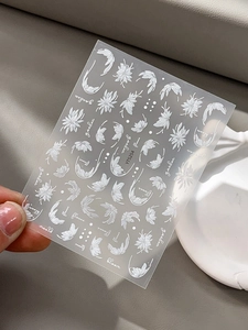 Vue détaillée d'autocollants nail art blancs avec fleurs en relief et texte de jardin