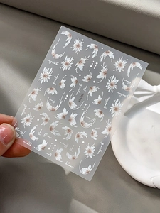 Détails d'autocollants pour ongles avec motifs marguerites blanches et lettrage fleuri