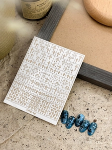 Detail of YITU-10 gold cross nail art stickers with 3D star elements on dark blue nails