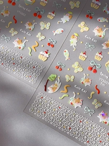 Macro shot of 3D embossed cat nail stickers with pastel colors and laser texture