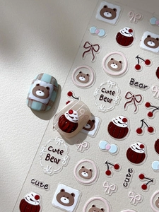 Détail d'autocollants 3D pour ongles avec des oursons mignons et des cerises
