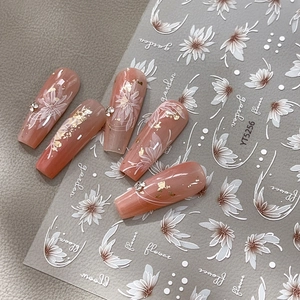 Stickers à ongles en relief avec fleurs blanches et feuille d'or sur faux ongles roses
