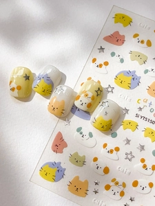 Detail of cute silver-stamped cat and dog nail art stickers with colorful star accents