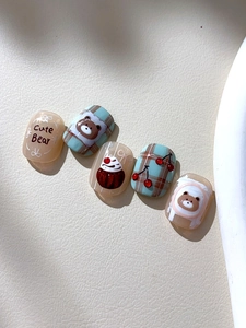Détail d'autocollants nail art avec ours mignon, cerises et motifs à carreaux