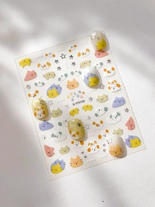 Close-up of cute silver cat and dog nail art stickers with colorful stars on nail tips