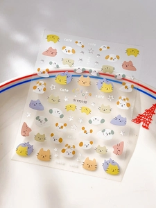 Detail showing cute silver-stamped cartoon cat and star nail art stickers on a white plate